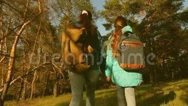 母女旅行者带着背包穿过<strong>树林</strong>。 在松林中的徒步旅行者。 <strong>游</strong>客喜欢